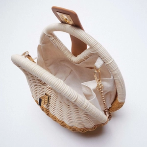 Shell-shaped woven straw handbag with brown leather flap and gold chain strap from above
