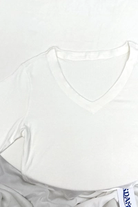 Close-up of the V-neckline and soft cotton fabric texture on this white slim-fit T-shirt