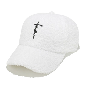 Dettaglio del berretto da baseball in sherpa bianco con ricamo croce 'Faith' sul davanti