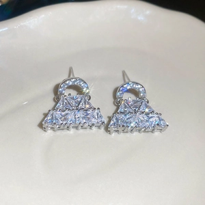 Macro di orecchini a borsa in argento con zirconi lucidi su vassoio in ceramica