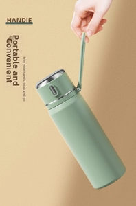 Close-up of a light green insulated water bottle featuring a portable silicone carrying loop