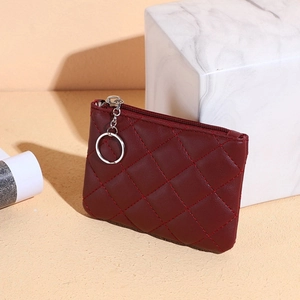 Close-up of wine red quilted leather coin purse with silver zipper and keychain hook