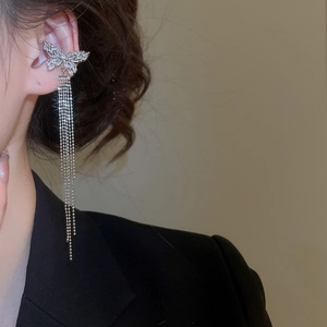 Detail of elegant silver butterfly ear cuff with sparkling zircon tassels on female model