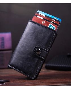 Detail view of the black lychee pattern leather wallet with a secure snap button closure