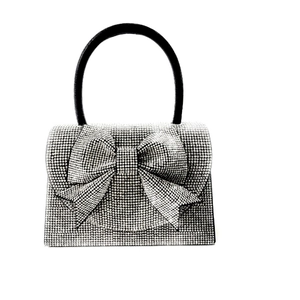 Silver rhinestone evening clutch bag with large bow and black curved handle for weddings