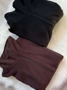 Detailed macro view of soft fleece fabric texture on folded black and brown sports jackets