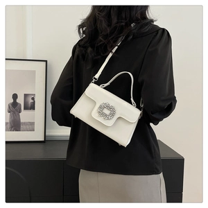 Vue arrière du mannequin portant un sac blanc à bandoulière avec boucle carrée diamantée