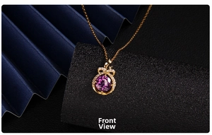 Close-up of golden necklace featuring a large purple zircon pendant and crystal bow detail