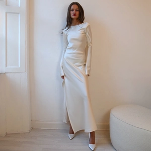 Elegant white long sleeve satin dress featuring a backless design and a stylish side slit