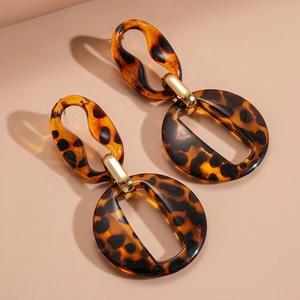 Macro view of leopard print acrylic geometric hoop earrings with polished tortoiseshell finish