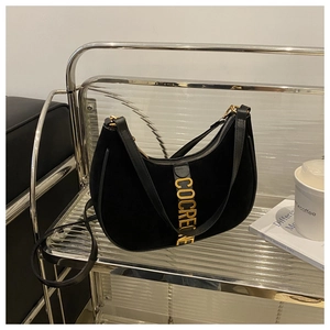 Detail of black matte leather crescent bag with elegant gold metal COCRENE logo lettering