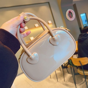 Detailed macro view of beige PVC jelly handbag with glossy finish and heart-shaped handle joints