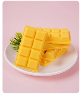 Detailed view of yellow PVC chocolate shape charms displayed on a white plate