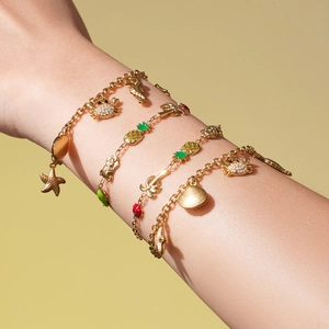 Ensemble de bracelets dorés à charms océan avec pendentifs coquillages et fruits