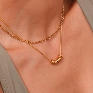 Double-layered 18K gold plated stainless steel necklace featuring bean pendant on model