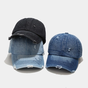 Detail of washed denim baseball caps with vintage distressed texture and embroidery