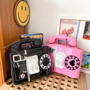 Detailed retro dial telephone handbags in pink and black patent leather finish