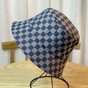 Blue-grey checkerboard denim bucket hat for women on a professional display stand