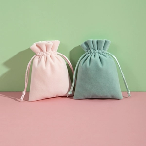 Pink and sage green plush velvet drawstring jewelry pouches with a soft matte finish
