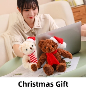 Detail of Happy Bear plush teddy with Christmas hat and striped scarf in a home setting