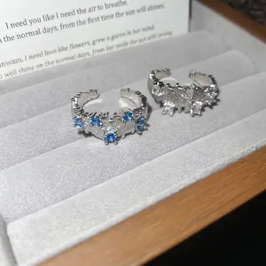 Irregular textured silver open ring with white and sky blue zircon stones