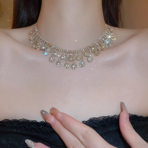 Close-up of gold flower tassel necklace with zircon stones worn by a model