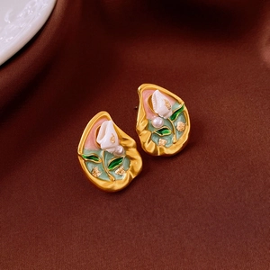 Detailed macro view of vintage enamel earrings with white flower and pearl accents