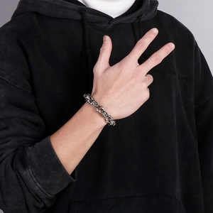 Punk style silver stainless steel double skull bracelet for men on male model's wrist