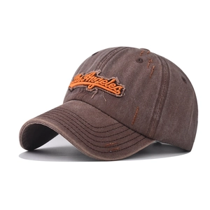 Close-up of vintage washed brown baseball cap with orange Los Angeles embroidery detail