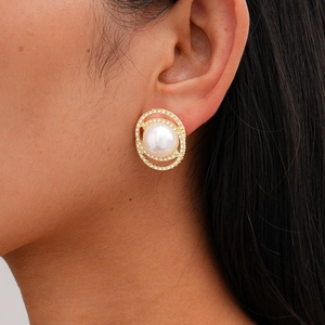 Close-up of elegant gold stud earring featuring a large pearl and double zircon rings