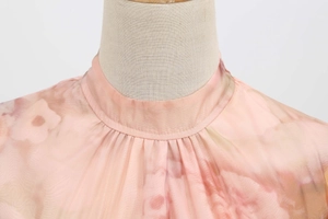 Close-up of pink floral chiffon dress with elegant high collar and mesh detailing