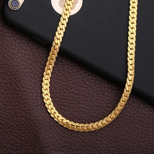 Minimalist 5mm gold curb chain necklace draped over a phone on leather texture