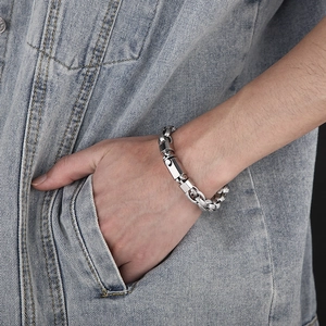 Silver chunky chain bracelet for men in industrial style worn on a denim jacket background