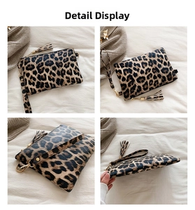 Detail view of leopard print clutch bag showing gold zipper, tassel and leather texture