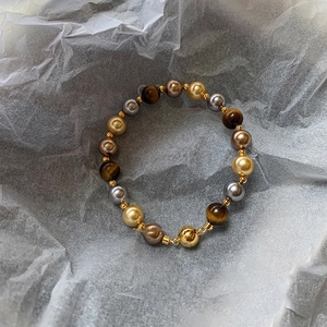 Détail macro du bracelet perlé vintage avec pierres œil de tigre et fermoir magnétique doré