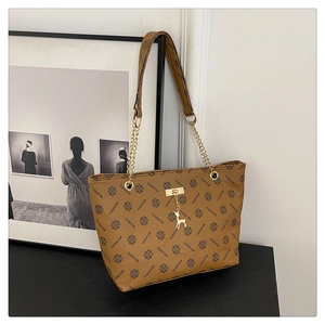 Detail of vintage monogram tote bag featuring golden deer charm and chain shoulder strap