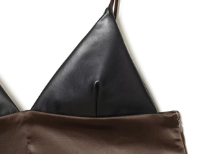 Detail view of black leather bustier joined with brown satin fabric and invisible zipper