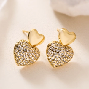 Macro view of 18K gold-plated double heart stud earrings with sparkling pavé cubic zirconia