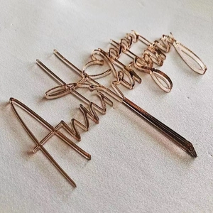 Close-up of rose gold acrylic Anniversary cake topper with elegant script and metallic finish