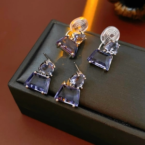 Macro shot of purple geometric zircon earrings with silver posts and clip-on backings