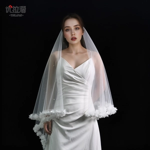 Detail of white bridal veil featuring delicate 3D floral lace edges and soft tulle layering