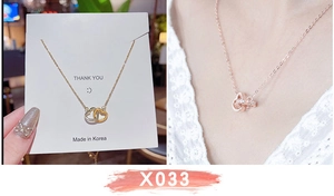 Dettaglio della collana con cuori intrecciati in oro e argento e piccoli cristalli