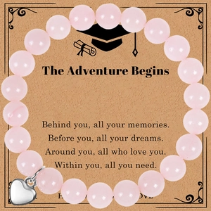 Detail of pink agate beaded bracelet with silver heart pendant on graduation gift card
