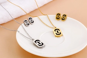 Detail view of gold and silver paperclip jewelry sets with black oval inlays on ceramic