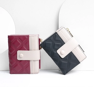 Detail of short wallets featuring quilted patterns and bicolor designs with metal zippers
