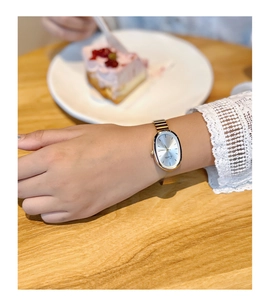 Close-up of elegant gold vintage oval watch for women on a cozy afternoon tea table