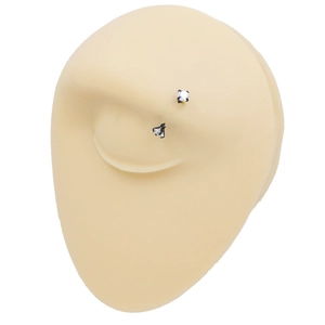 Detailed view of a black eyebrow piercing ring with white zircon on a silicone model