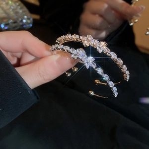 Close-up of gold-plated cluster earrings featuring brilliant marquise-cut white zircons