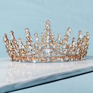 Luxurious gold bridal crown with sparkling crystals on a marble base