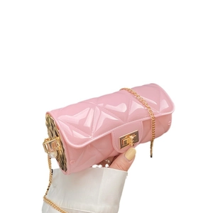 Pink quilted cylinder jelly bag with gold chain and pearl accents on white background